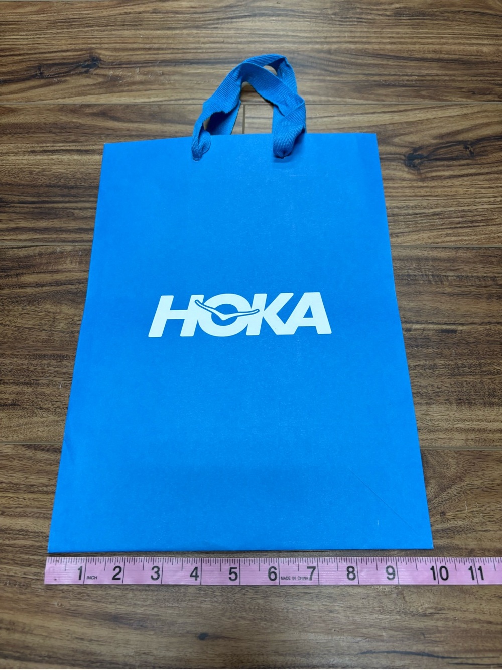 HOKA logo bright blue paper shopping bag from the athletic brand